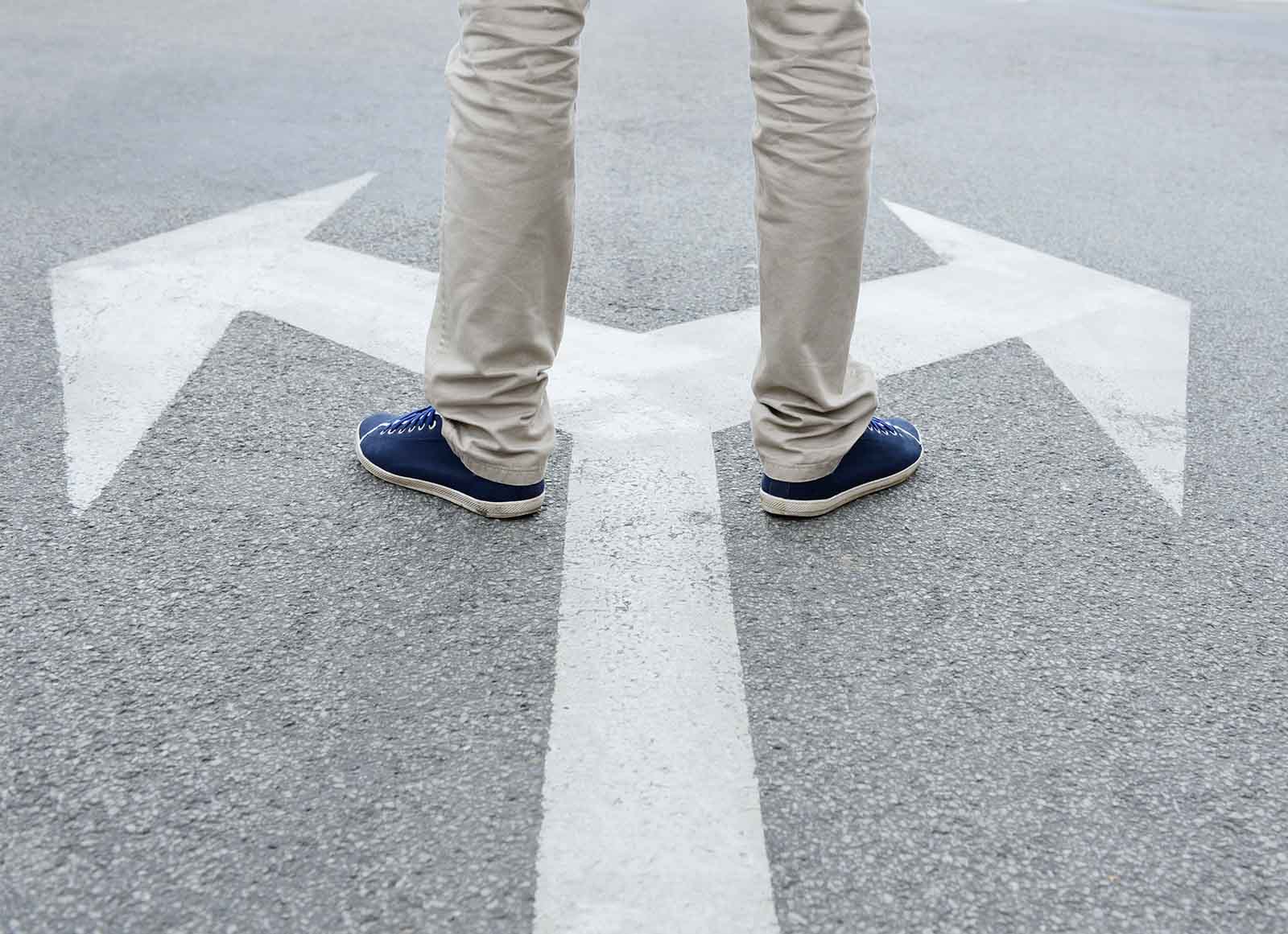 Feet standing on arrows painted on ground